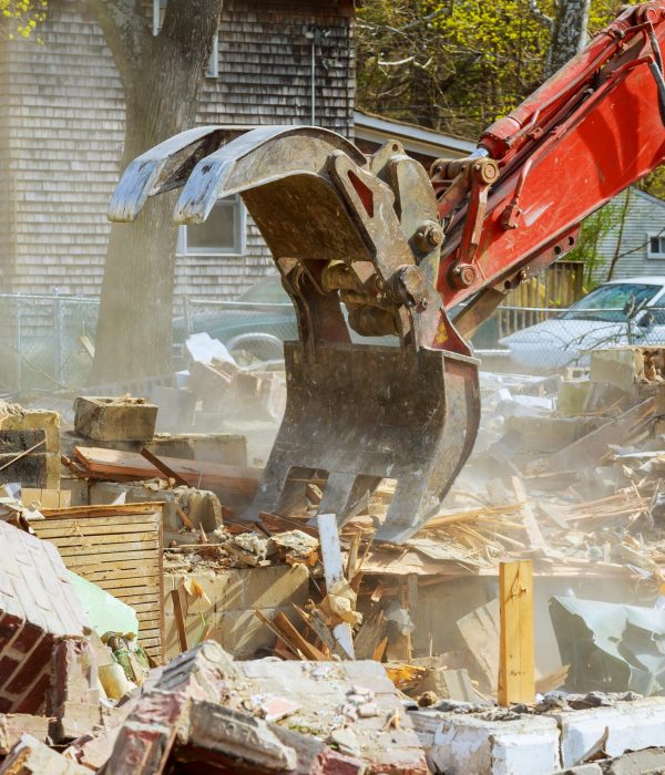 Demolition of an old house, wooden planks and rubble and the ruins of the house for new construction project.